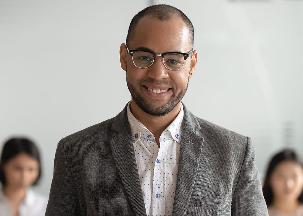man in suit standing in front of two women